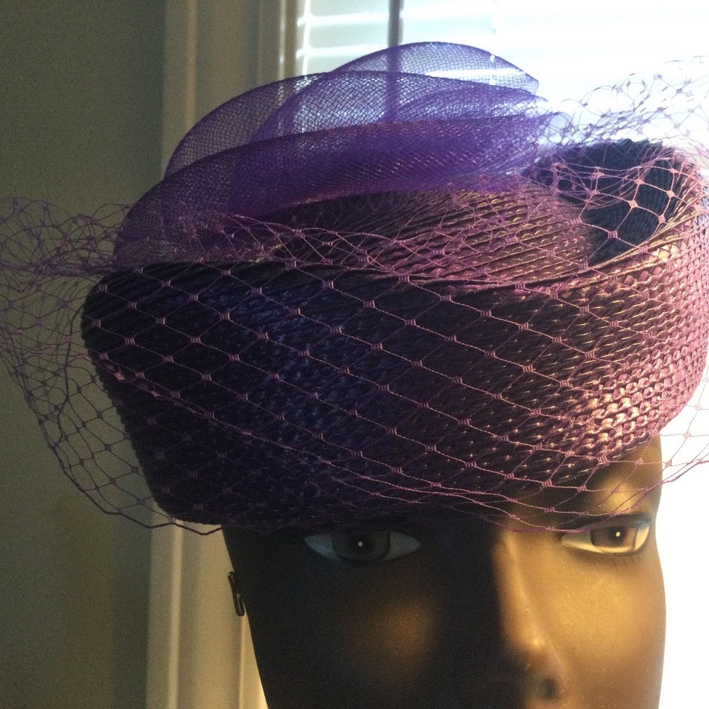 Purple pillbox style hat with face netting.